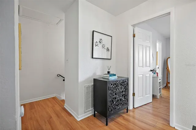 a view of a hallway with wooden floor and a bedroom