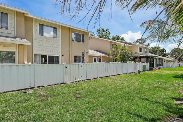 a view of backyard with potted plants and wooden fence