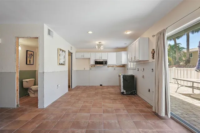 a view of a kitchen with refrigerator and wooden floor