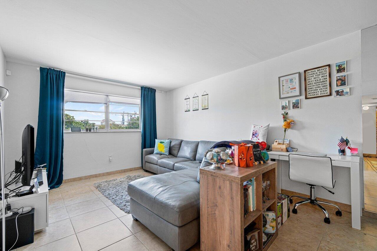 600 Southwest 2nd Street, Unit 2390 Boca Raton, FL 33486 - Photo 2 of 18 a room with furniture a flat screen tv and a window