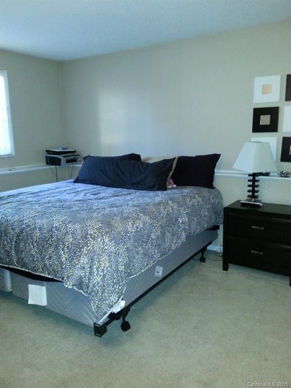 20119 Henderson Road, Unit A Cornelius, NC 28031 - Photo 12 of 13 a bedroom with a bed and a lamp