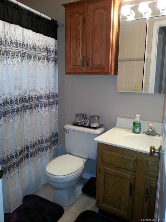 20119 Henderson Road, Unit A Cornelius, NC 28031 - Photo 13 of 13 a bathroom with a granite countertop toilet sink and mirror