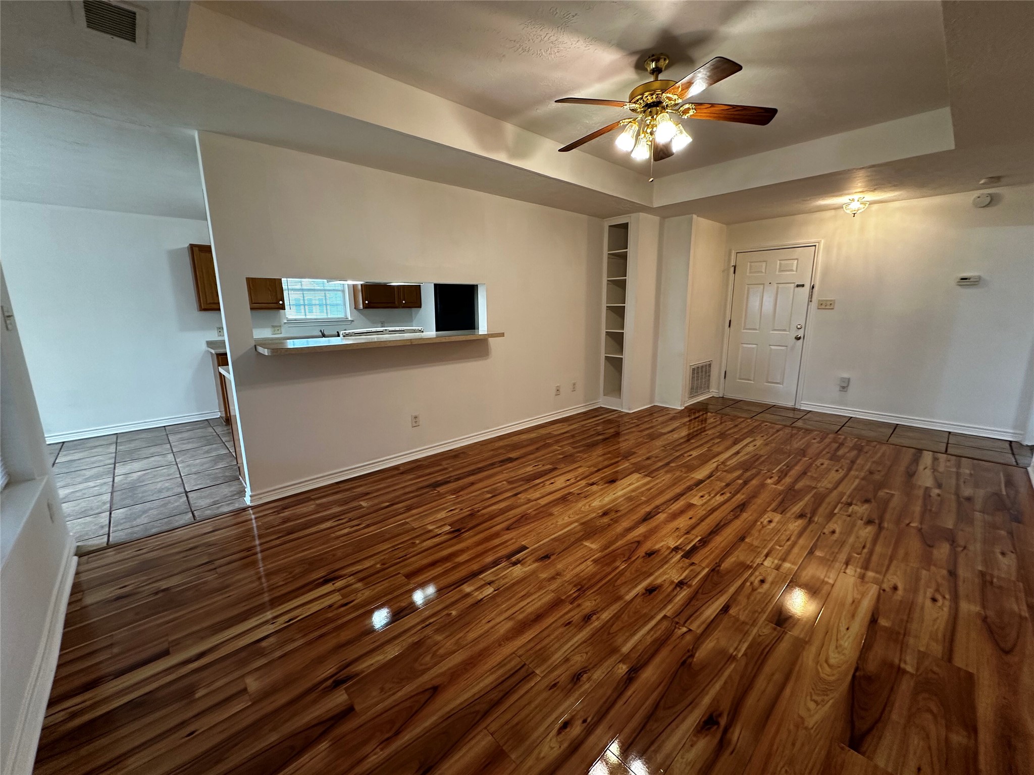 1400 Prairie Drive Bryan, TX 77802 - Photo 5 of 18 Natural wood flooring complements built-in shelving, creating an inviting living area.