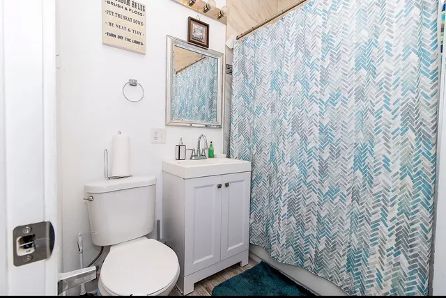 a bathroom with a toilet sink and a mirror