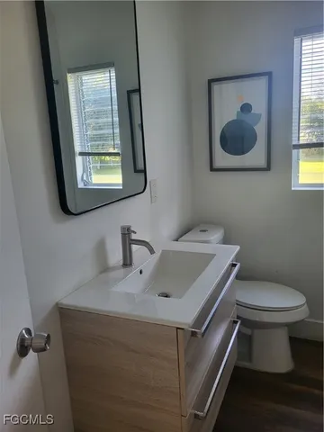 a bathroom with a toilet sink and mirror