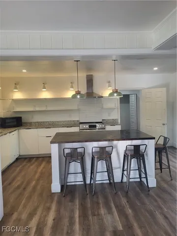 a kitchen with stainless steel appliances granite countertop a white cabinets and stove top oven