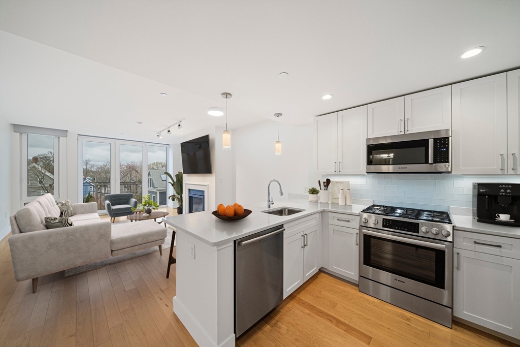a view of kitchen with sink stainless steel appliances and cabinets