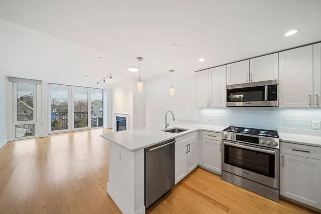 a kitchen with stainless steel appliances a stove sink microwave and cabinets