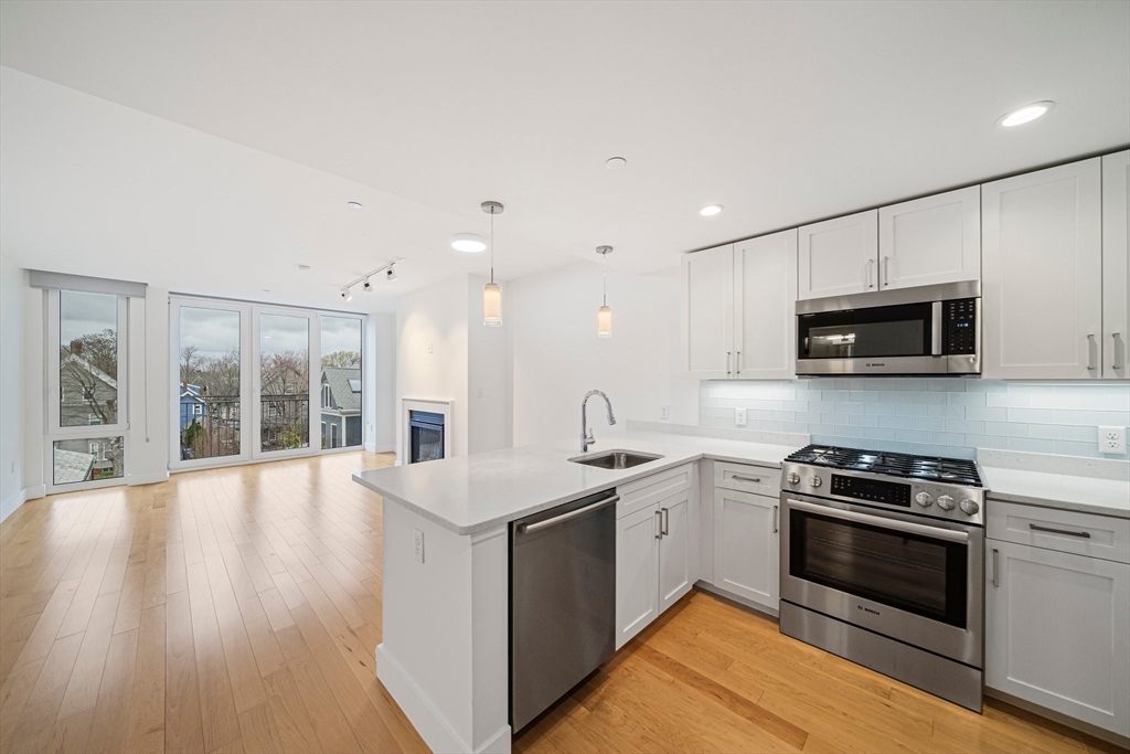 7 Beech Street, Unit 319 Cambridge, MA 02140 - Photo 2 of 27 a kitchen with stainless steel appliances a stove sink microwave and cabinets