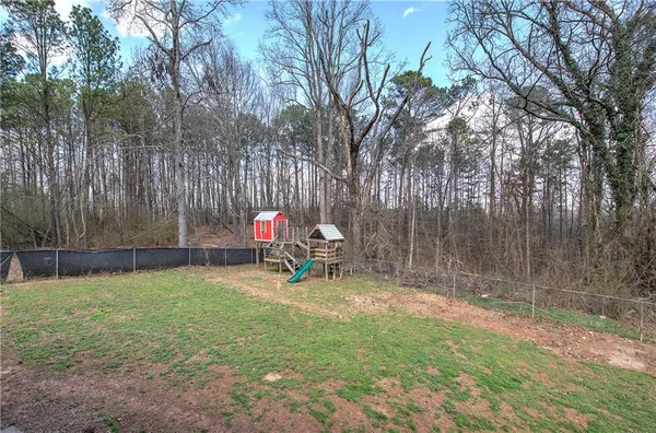 a view of a backyard with table and chairs and a tree