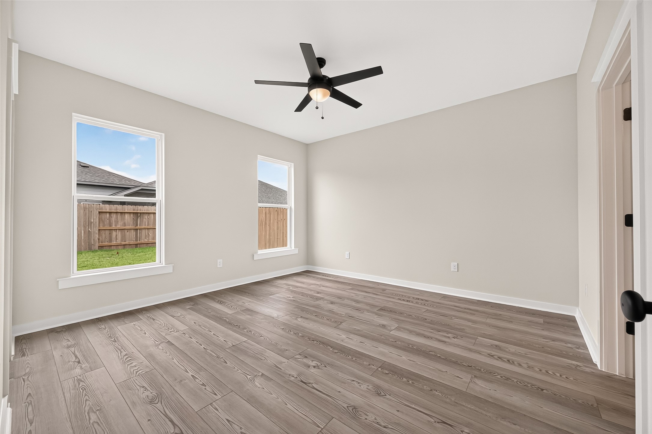 21122 Autumn Heights Rosharon, TX 77583 - Photo 22 of 42 an empty room with wooden floor a ceiling fan and windows