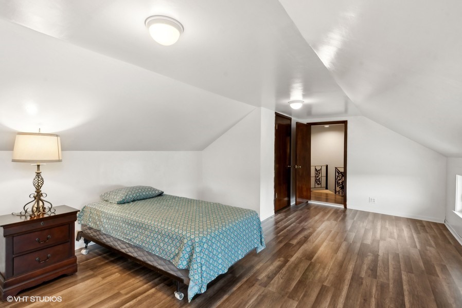 11719 Engelhardt Road Harvard, IL 60033 - Photo 13 of 18 a bedroom with a bed and wooden floor