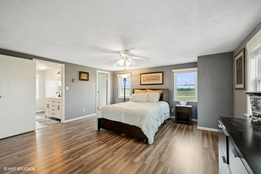 11719 Engelhardt Road Harvard, IL 60033 - Photo 9 of 18 a bedroom with a large bed wooden floor and window