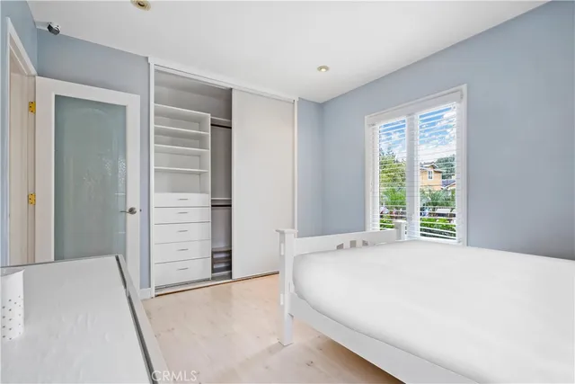 a large bed sitting in a bedroom next to a window and dresser