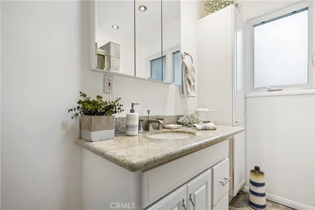 a bathroom with a granite countertop sink and a mirror