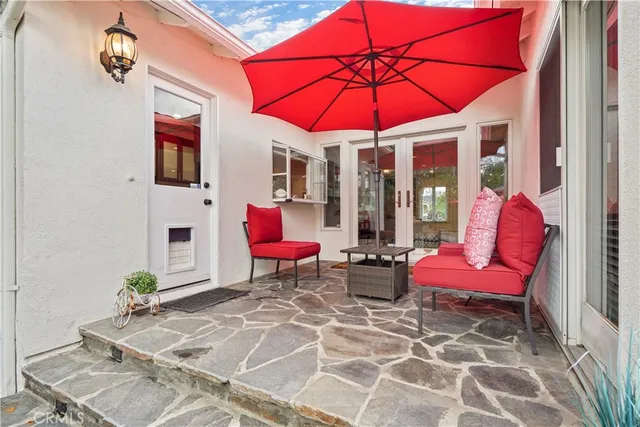 a view of a patio with a table and chairs under an umbrella