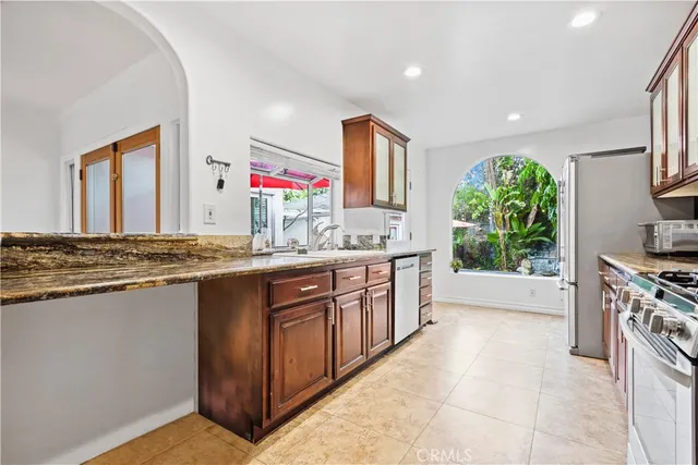 a kitchen with stainless steel appliances granite countertop a stove a sink and a refrigerator