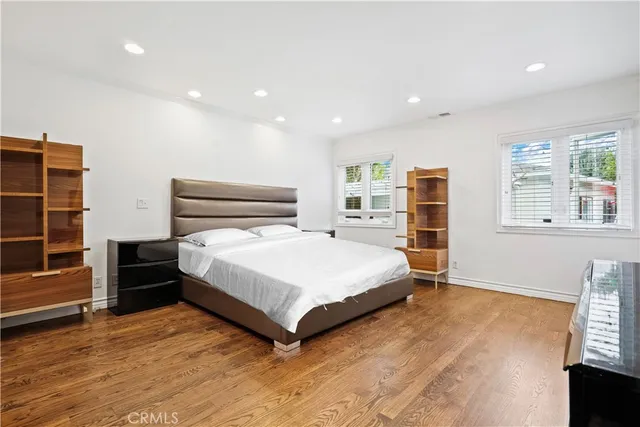 a spacious bedroom with a bed and wooden floor