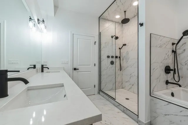 a bathroom with a tub sink a mirror and shower