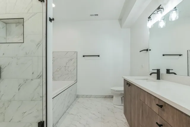 a bathroom with a sink a toilet and shower