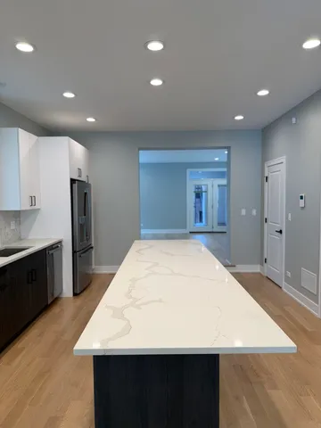 a large kitchen with kitchen island a sink stainless steel appliances and cabinets