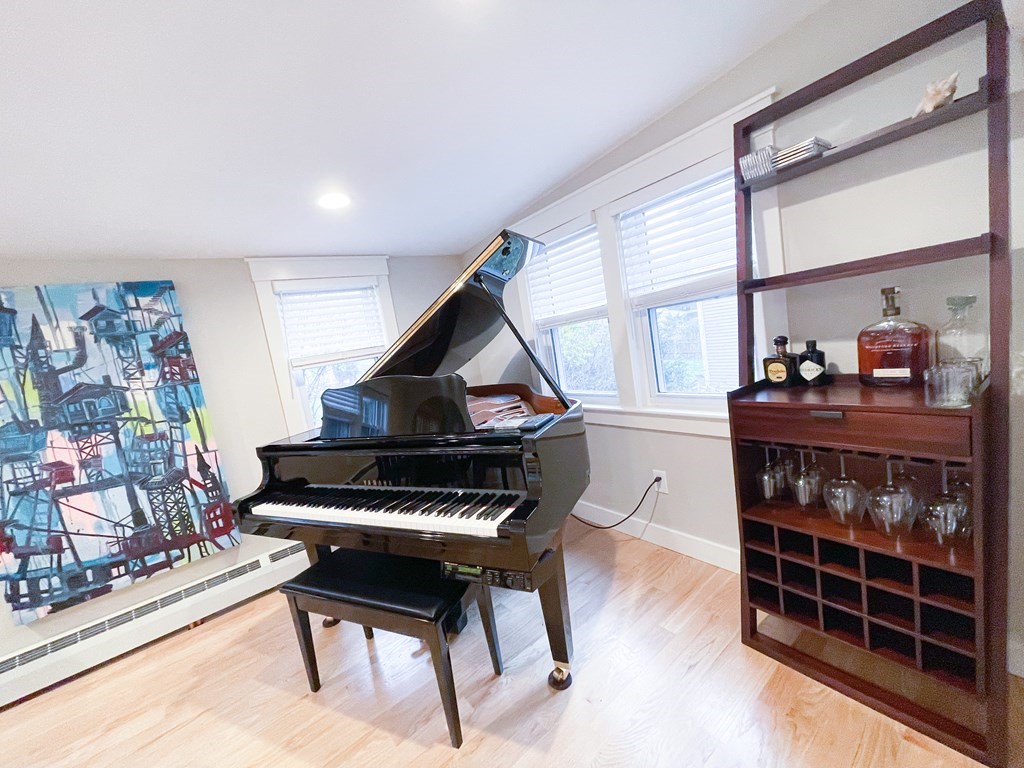 83 Rockridge Road Waltham, MA 02453 - Photo 1 of 16 a living room with furniture a piano and a floor to ceiling window