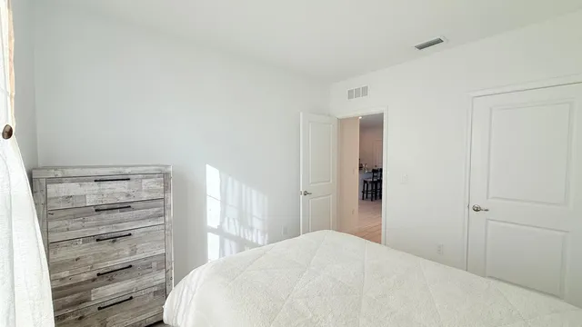 a bedroom with a bed and a wooden floor