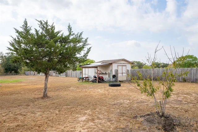 a view of a house with backyard and trees