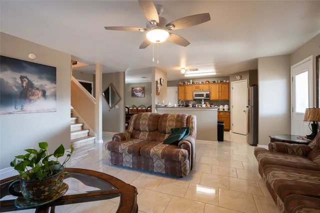 a living room with furniture kitchen view and a chandelier