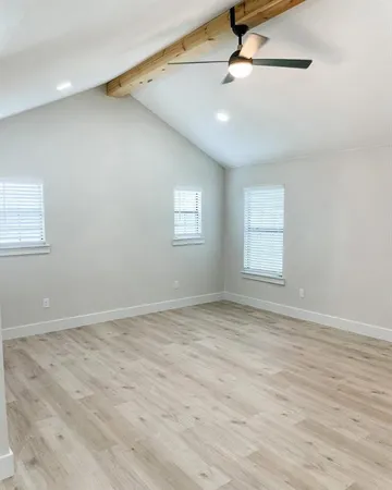 an empty room with windows and fan