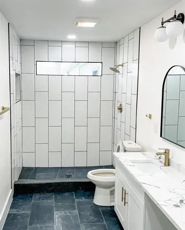 a bathroom with a sink a toilet and shower