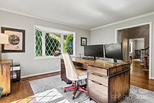 a view of a workspace with furniture and a window