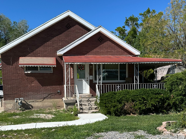 8320 West 3100th Street South Magna, UT 84044 - Photo 1 of 41 View of front facade with covered porch, brick siding, and a front lawn