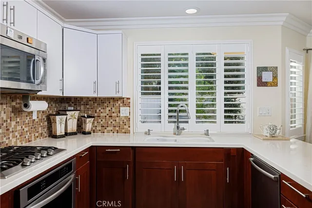 a kitchen with stainless steel appliances kitchen island granite countertop a sink stove and cabinets