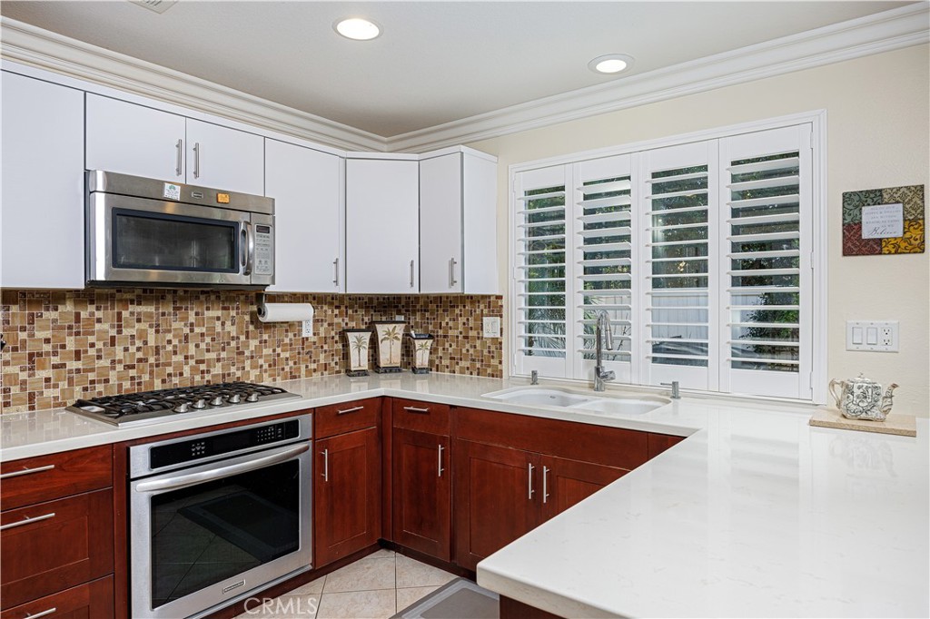 14 Sorenson Irvine, CA 92602 - Photo 14 of 29 a kitchen with stainless steel appliances granite countertop a sink a stove a microwave and wooden cabinets