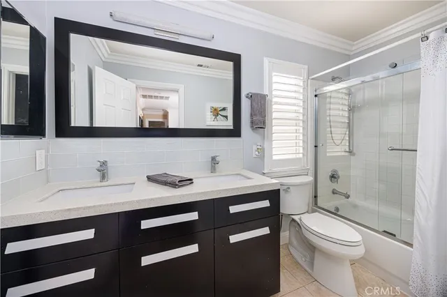 a bathroom with a granite countertop toilet a sink a mirror and a shower