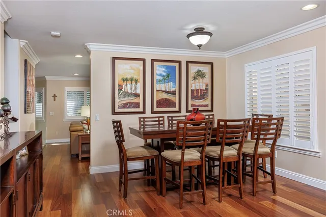 a view of a a dining room with furniture window and wooden floor