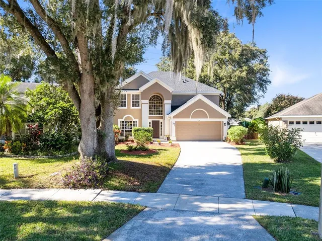 a front view of a house with a yard and trees