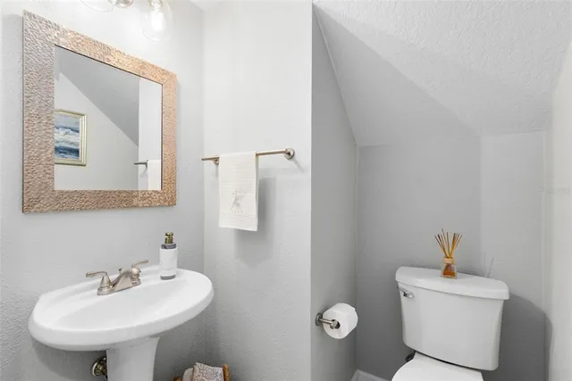 a bathroom with a sink toilet and mirror