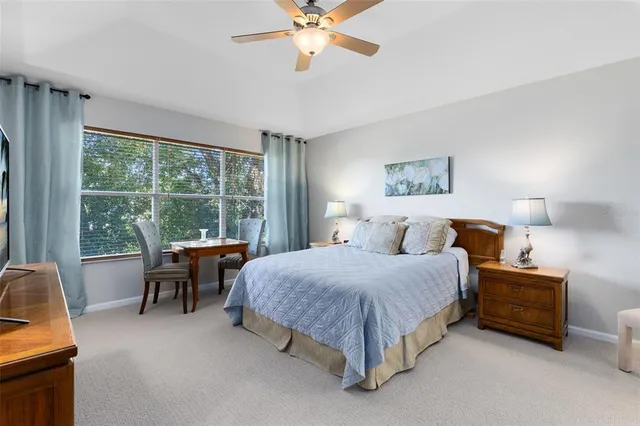 a spacious bedroom with a bed and a chandelier