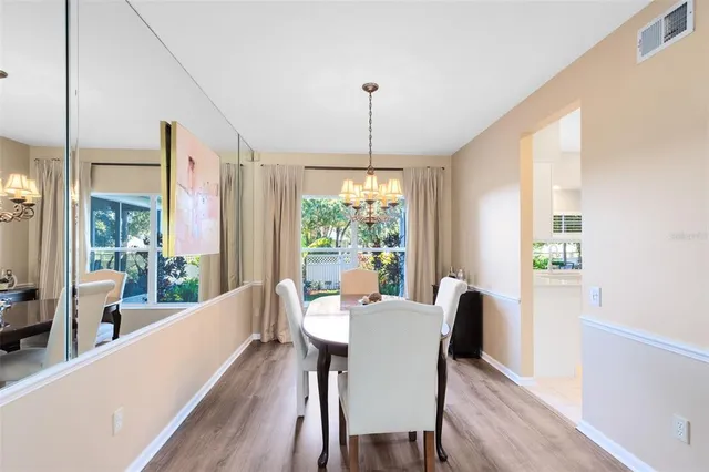 a dining room with furniture a chandelier and wooden floor