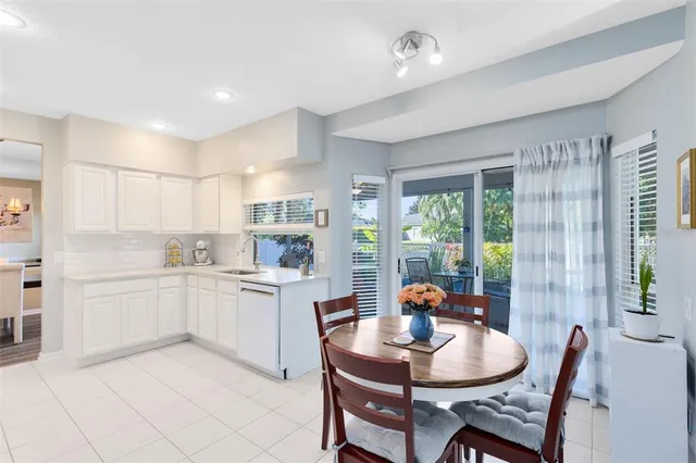 a open dining room with stainless steel appliances granite countertop a stove a table and chairs