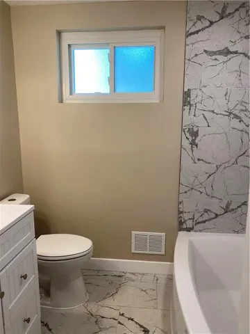 a white toilet sitting next to a shower