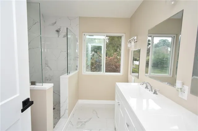 a spacious bathroom with a tub sink and mirror
