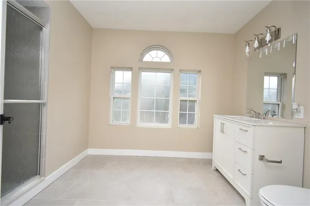 a spacious bathroom with a toilet sink and mirror