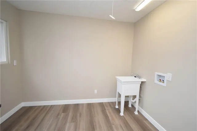an empty room with wooden floor and a window