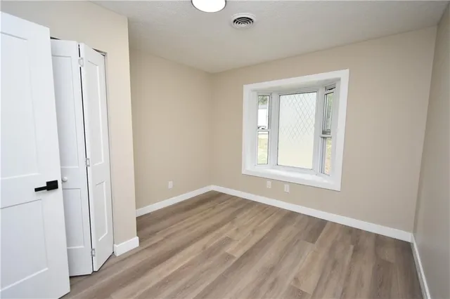 an empty room with wooden floor and a window