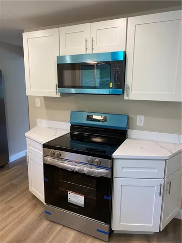 a kitchen with stainless steel appliances a stove a microwave and cabinets