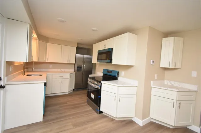 a kitchen with white cabinets sink and white appliances