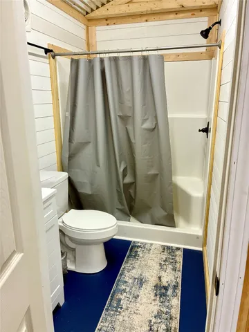 a bathroom with a toilet and a shower